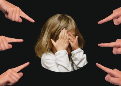 A group of fingers pointing at a girl's face